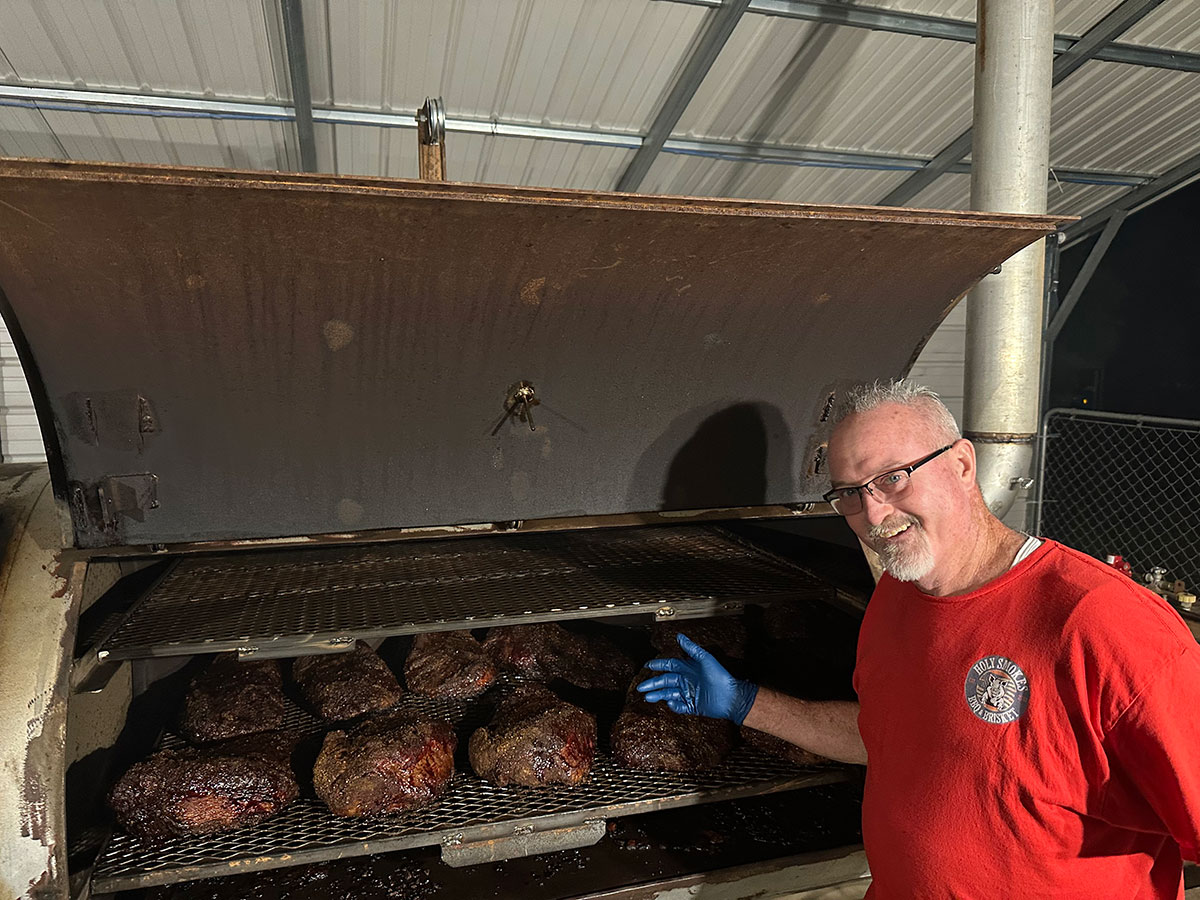 Briskets lined up on the smoker grate