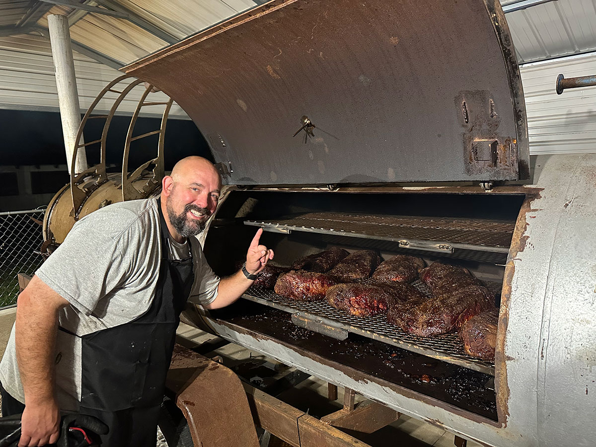 Pitmaster pulling tender smoked brisket from the Holy Smokes smoker