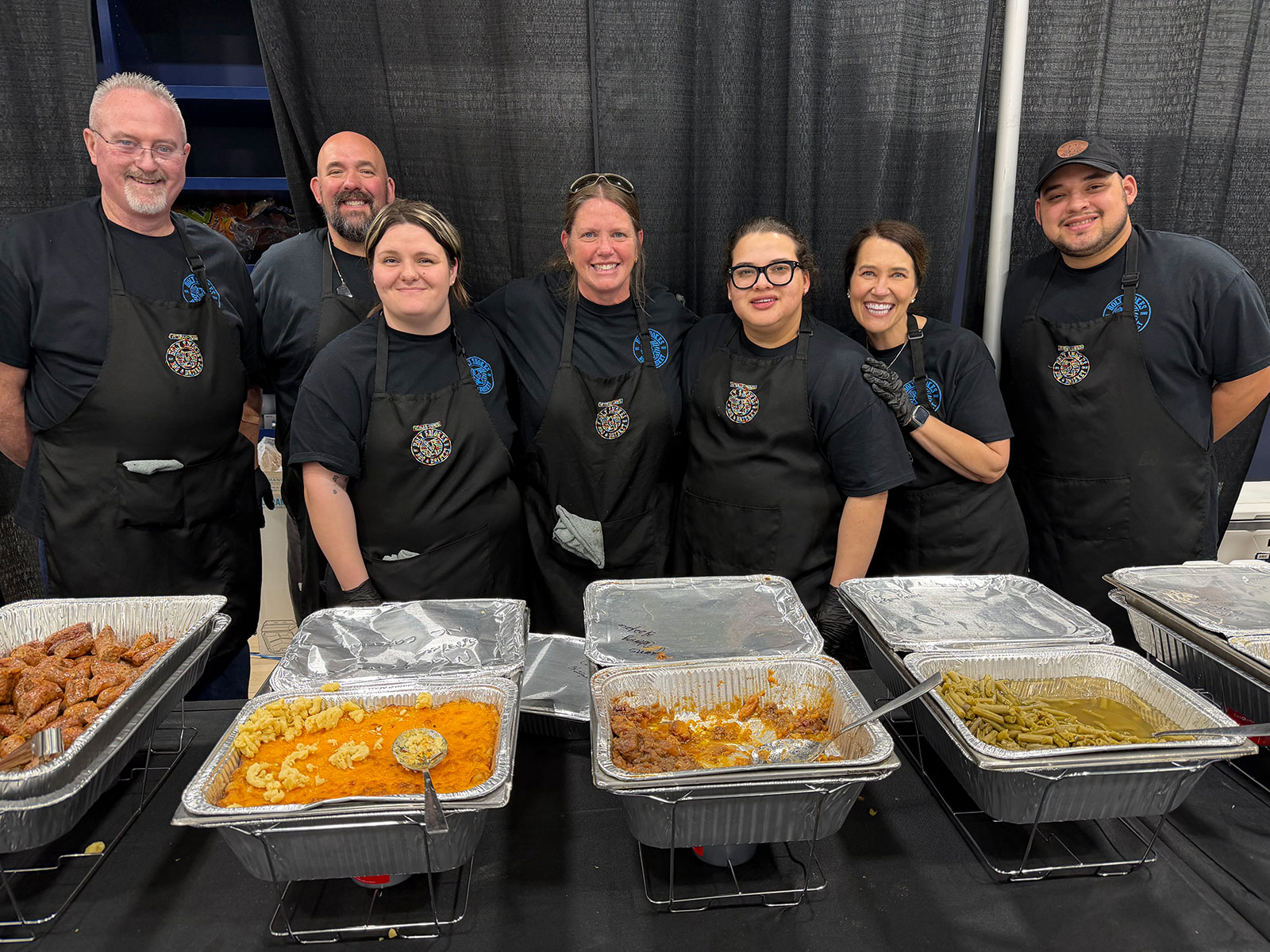 Trays of barbecue, mac and cheese, beans and greens ready for a Holy Smokes catered event